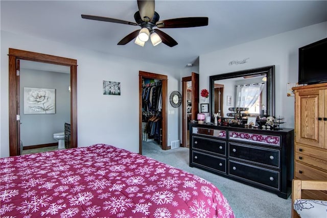 carpeted bedroom with ensuite bathroom, ceiling fan, a spacious closet, and a closet