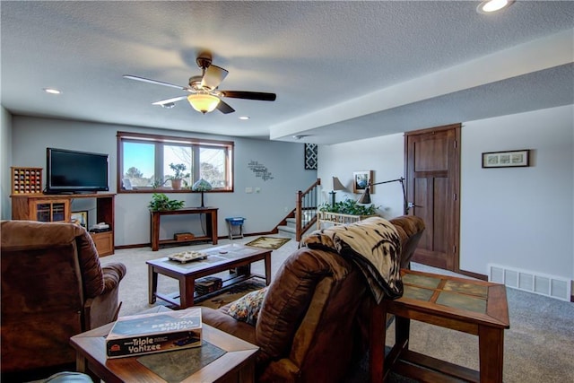 carpeted living room with a textured ceiling and ceiling fan