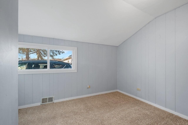 carpeted spare room with lofted ceiling