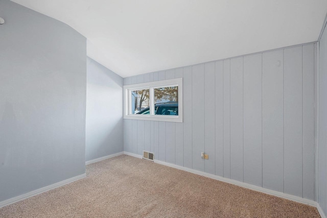 unfurnished room with lofted ceiling and carpet floors