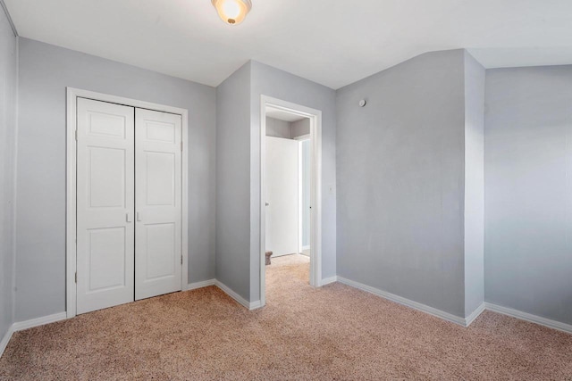 unfurnished bedroom with light colored carpet and a closet