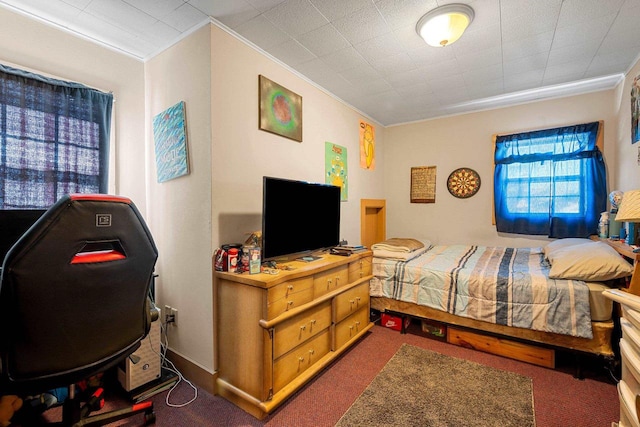 bedroom with ornamental molding and dark carpet