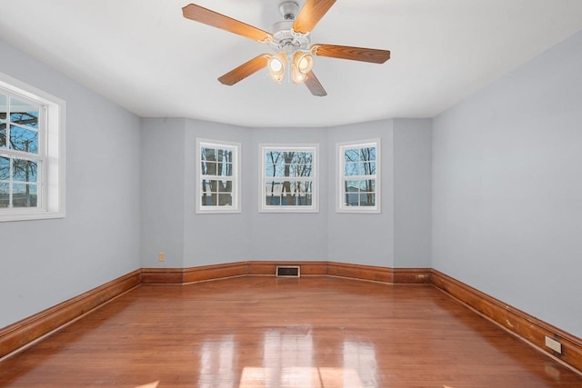 unfurnished room featuring light wood-type flooring, ceiling fan, and plenty of natural light