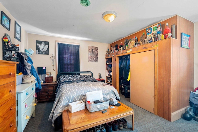 bedroom featuring wooden walls, a closet, and carpet flooring