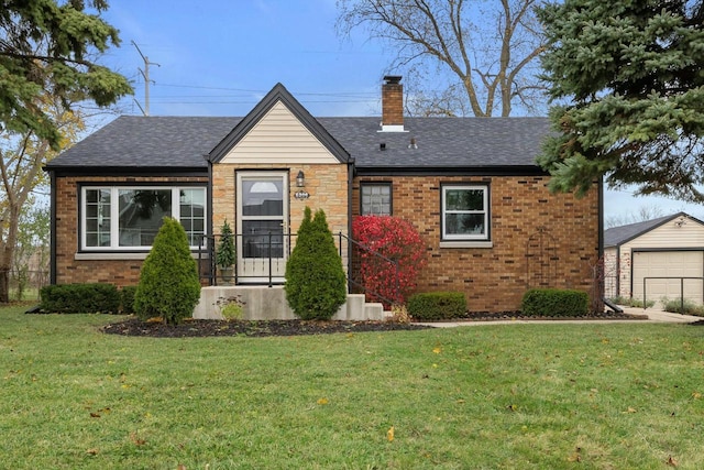 view of front of house with a front lawn, a garage, and an outdoor structure