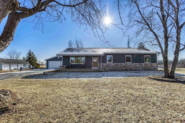 ranch-style house featuring a front lawn and a garage