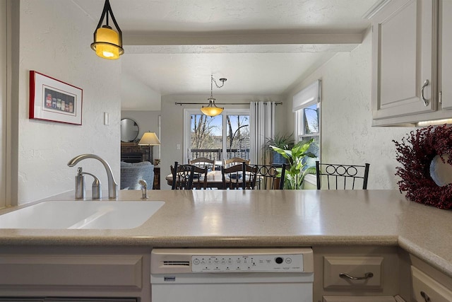 kitchen with white dishwasher, hanging light fixtures, and sink