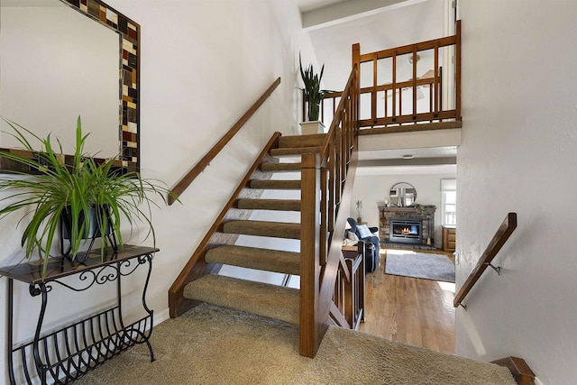 stairs with a towering ceiling and wood-type flooring