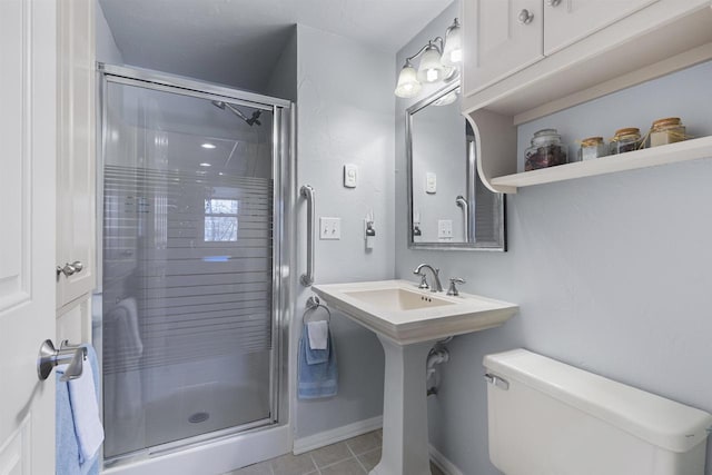 bathroom featuring toilet, tile patterned floors, and a shower with door