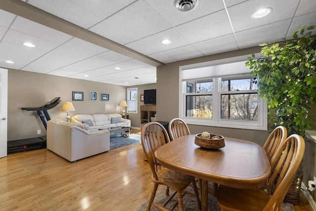 dining room featuring light hardwood / wood-style floors and a drop ceiling