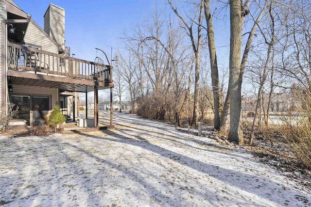 yard layered in snow with a wooden deck