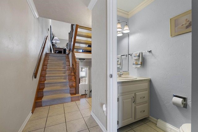 stairway featuring crown molding, tile patterned floors, and sink