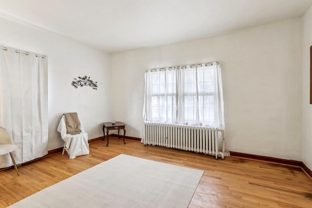 living area with radiator and wood-type flooring