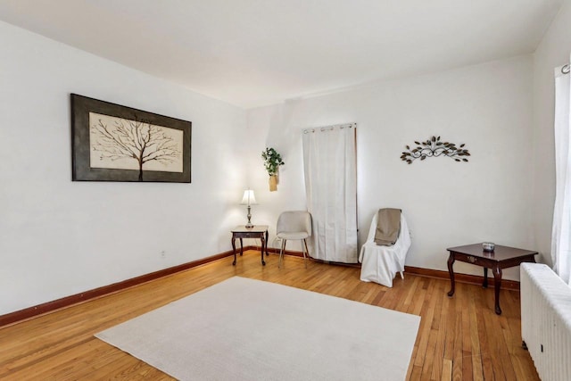 sitting room featuring hardwood / wood-style flooring and radiator heating unit