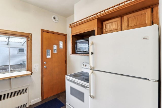 kitchen featuring radiator and white appliances