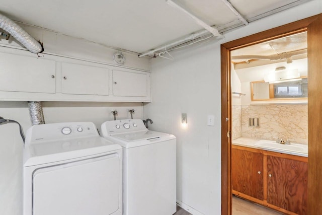 laundry room featuring cabinets, washer and clothes dryer, and sink