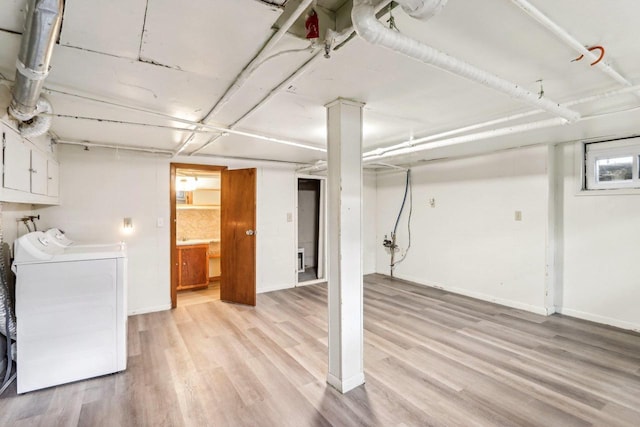 basement with light wood-type flooring and independent washer and dryer