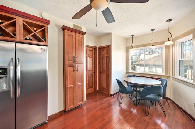 dining room featuring ceiling fan, a textured ceiling, and dark hardwood / wood-style floors