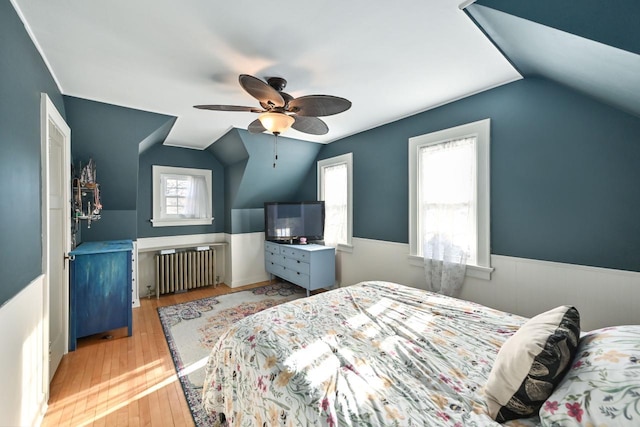 bedroom with ceiling fan, light wood-type flooring, radiator heating unit, and lofted ceiling