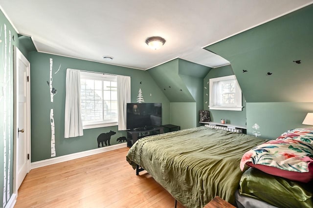 bedroom with light hardwood / wood-style floors and lofted ceiling