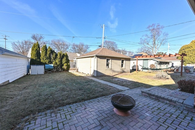 view of yard with an outbuilding, an outdoor fire pit, and a patio area