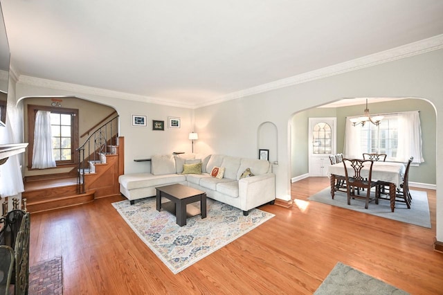 living room with an inviting chandelier, ornamental molding, and hardwood / wood-style flooring