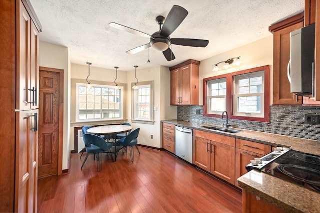 kitchen featuring appliances with stainless steel finishes, backsplash, pendant lighting, and sink