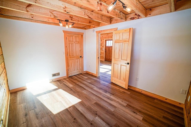 unfurnished room with beam ceiling, wooden ceiling, and wood-type flooring