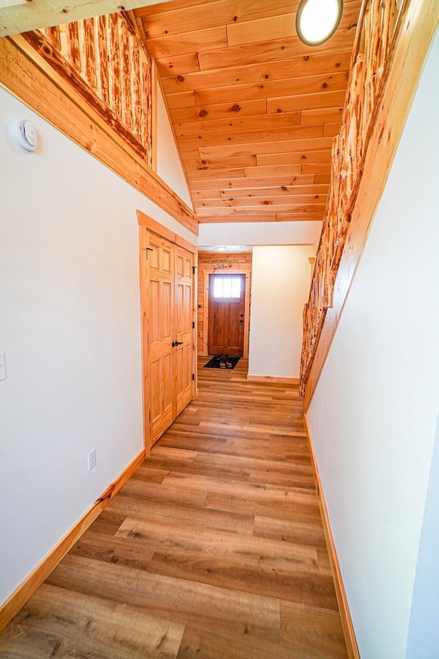 corridor with high vaulted ceiling, wood-type flooring, and wooden ceiling