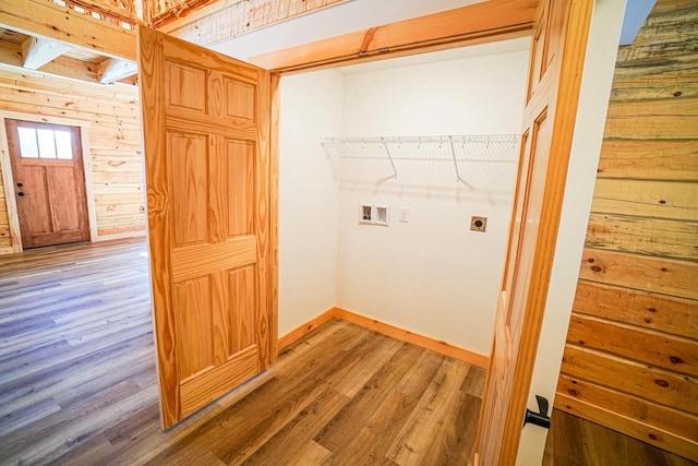 laundry area with hookup for a washing machine, wood walls, hardwood / wood-style flooring, and hookup for an electric dryer