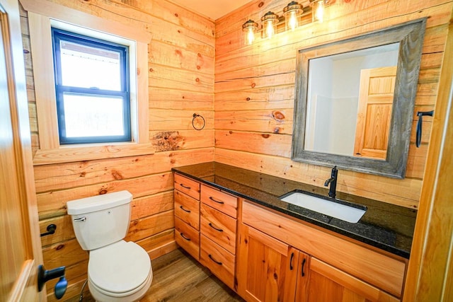 bathroom featuring hardwood / wood-style floors, wood walls, and vanity