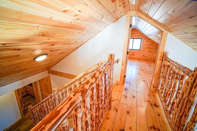 hallway featuring lofted ceiling, wood walls, hardwood / wood-style floors, and wood ceiling