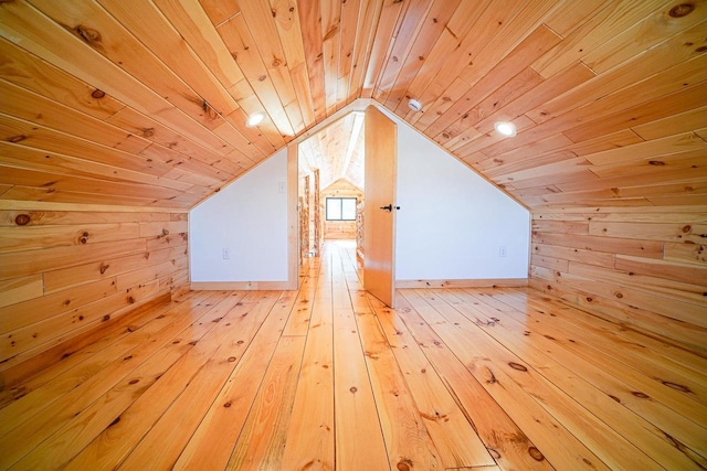 additional living space featuring lofted ceiling, wooden walls, wooden ceiling, and light wood-type flooring