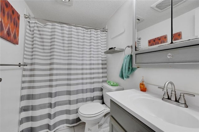 bathroom with toilet, tile patterned flooring, a textured ceiling, and vanity