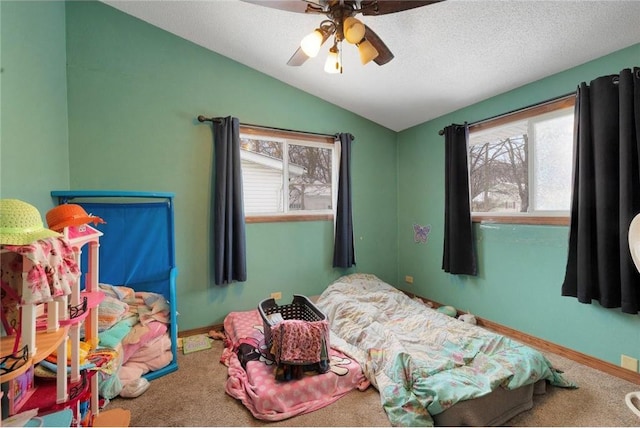 carpeted bedroom with lofted ceiling, a textured ceiling, and ceiling fan