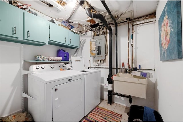 clothes washing area with electric panel, cabinets, sink, and washing machine and clothes dryer