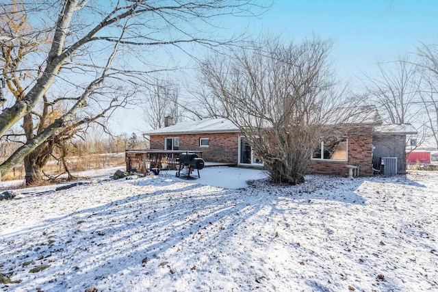 snow covered rear of property with central AC unit