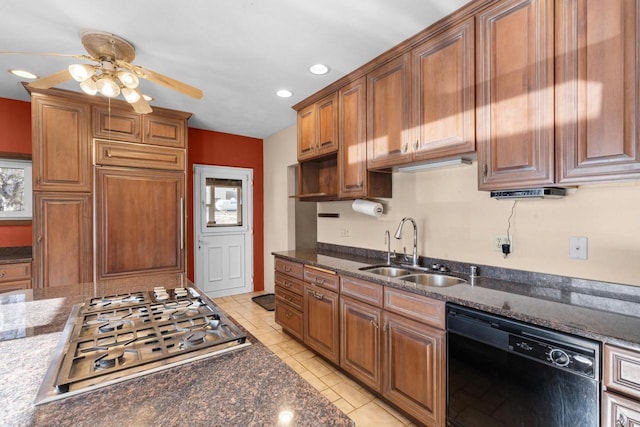 kitchen featuring dishwasher, light tile patterned floors, stainless steel gas cooktop, dark stone counters, and sink