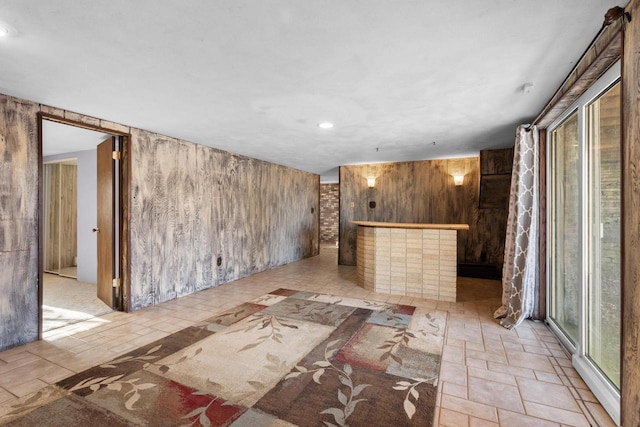 spare room featuring a fireplace and wooden walls