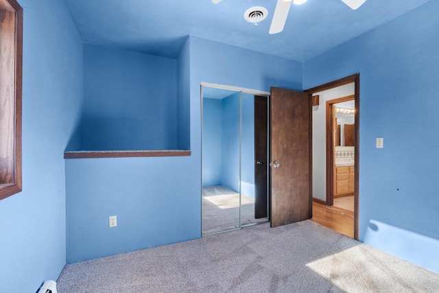 carpeted bedroom with ceiling fan and a closet