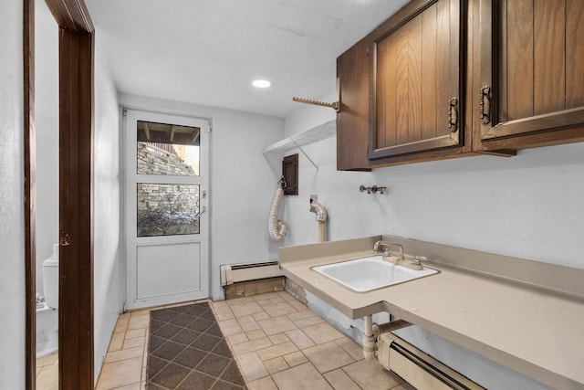 laundry room featuring sink, a baseboard heating unit, hookup for a washing machine, and cabinets