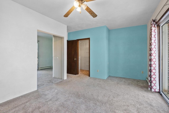 unfurnished bedroom featuring ceiling fan, baseboard heating, multiple windows, and light carpet