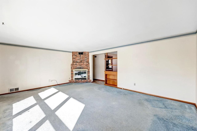 unfurnished living room featuring crown molding, carpet flooring, and a fireplace