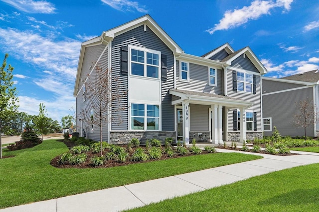 craftsman inspired home with covered porch and a front yard