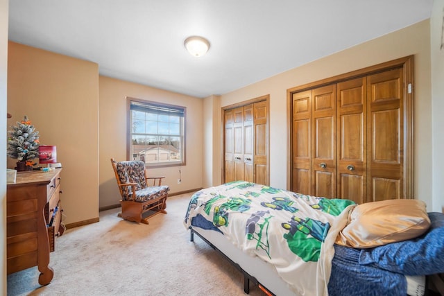 bedroom featuring two closets and light carpet