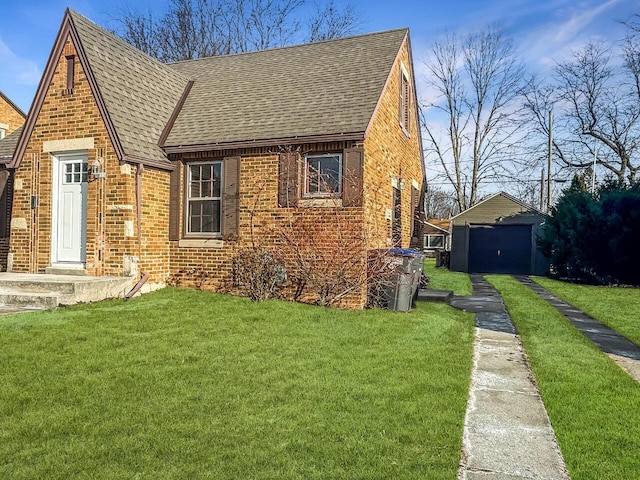 view of front facade with a garage, an outbuilding, and a front lawn