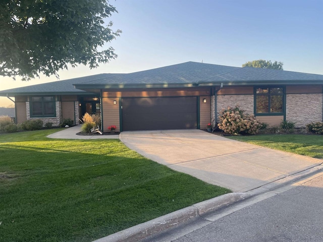 prairie-style house featuring a front lawn and a garage