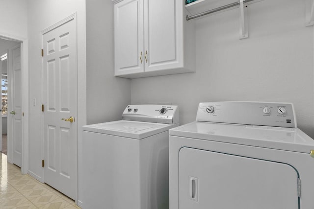 laundry room with washer and dryer and cabinets