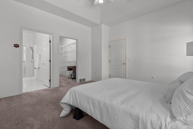 bedroom featuring a closet, light carpet, ceiling fan, a spacious closet, and ensuite bathroom