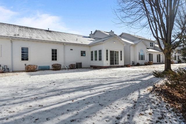 snow covered property with central AC